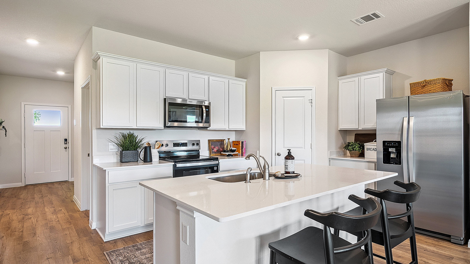 Kitchen featuring white cabinets, new stainless steel appliances, and white countertops.