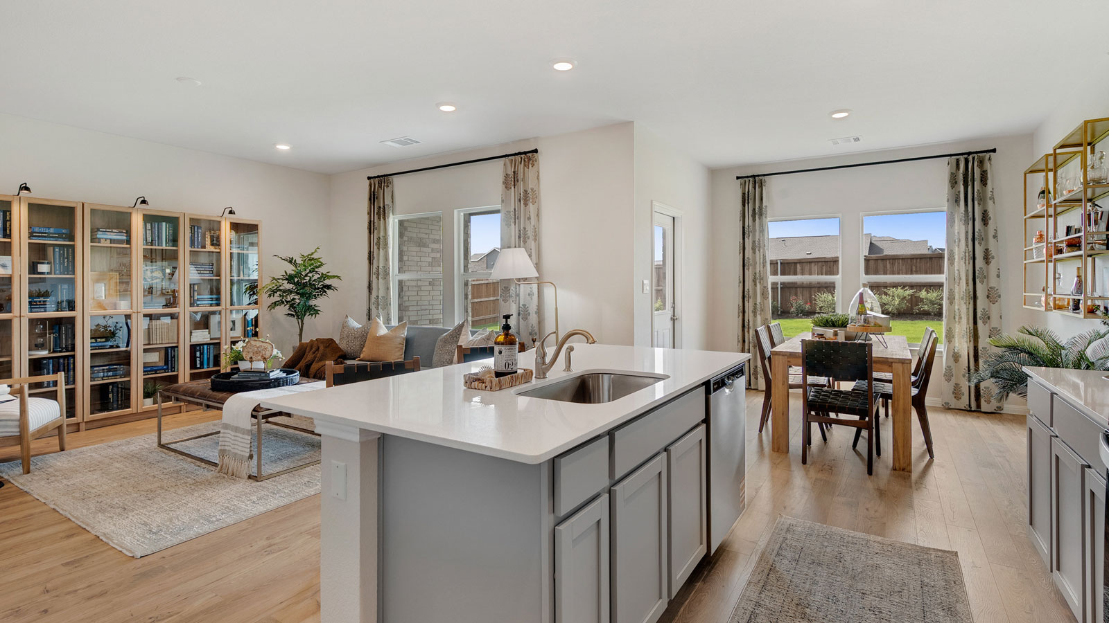 Open concept kitchen area connecting to living and dining space.