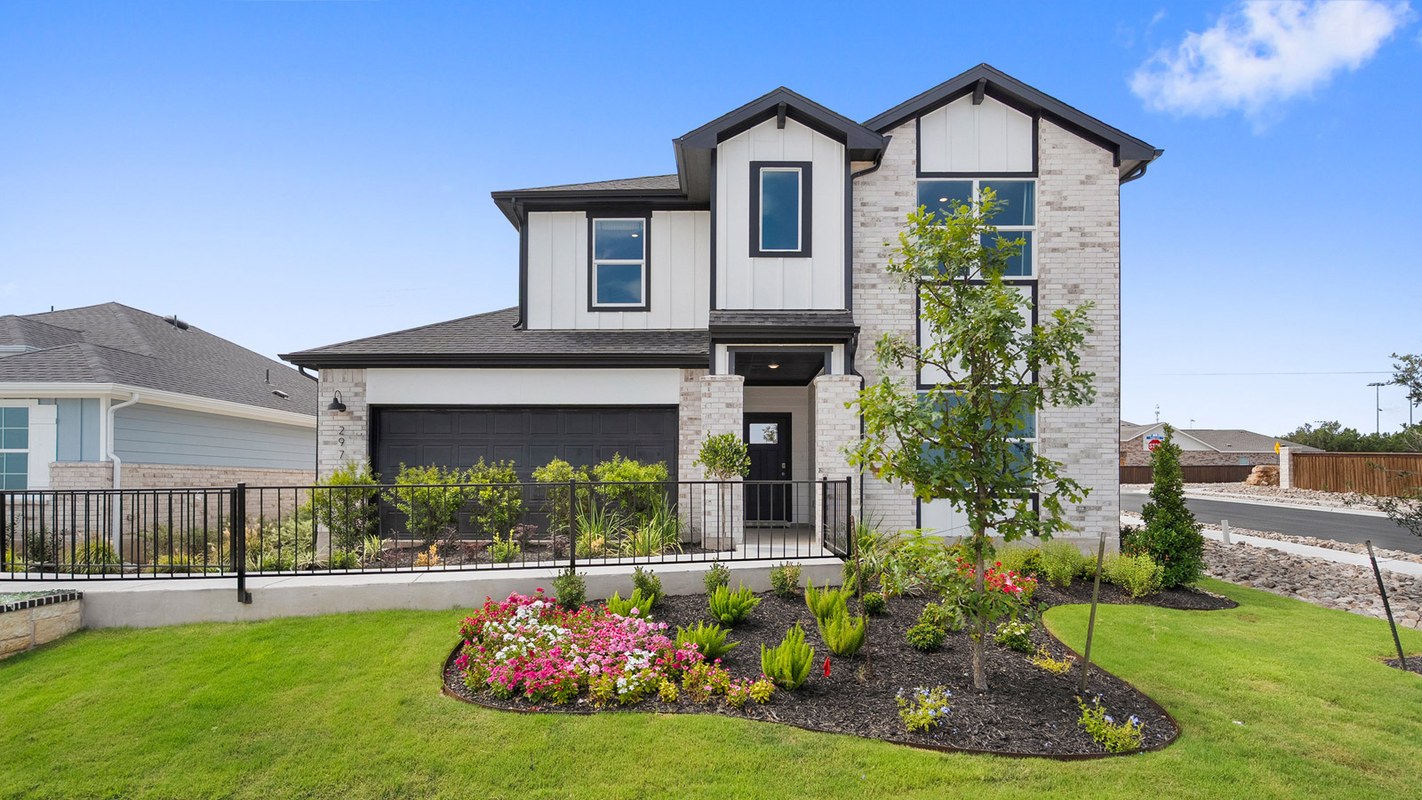Two story home with attached garage and clean landscaping