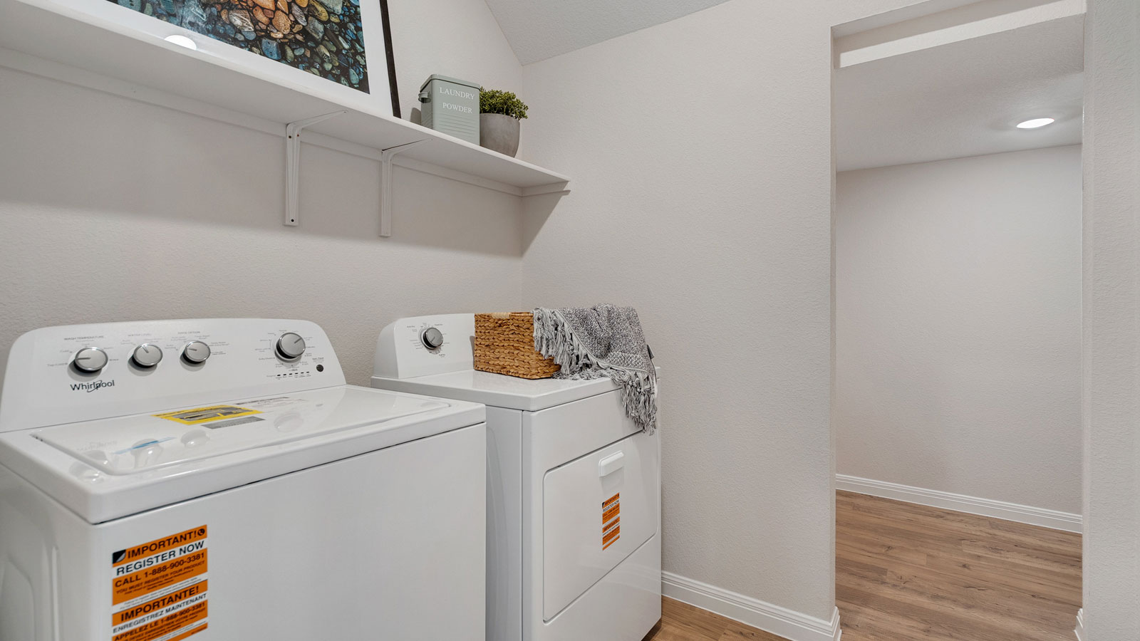 Laundry room with shelving above appliances.