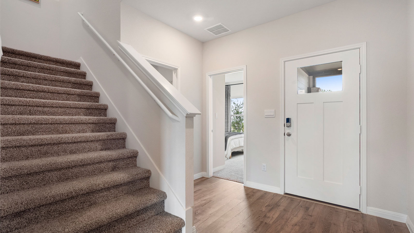 Entryway hallway with carpeted staircase.