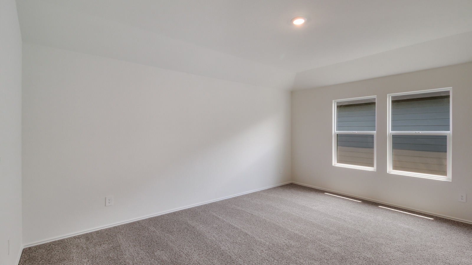 Bedroom 1 with carpeted flooring and large window.