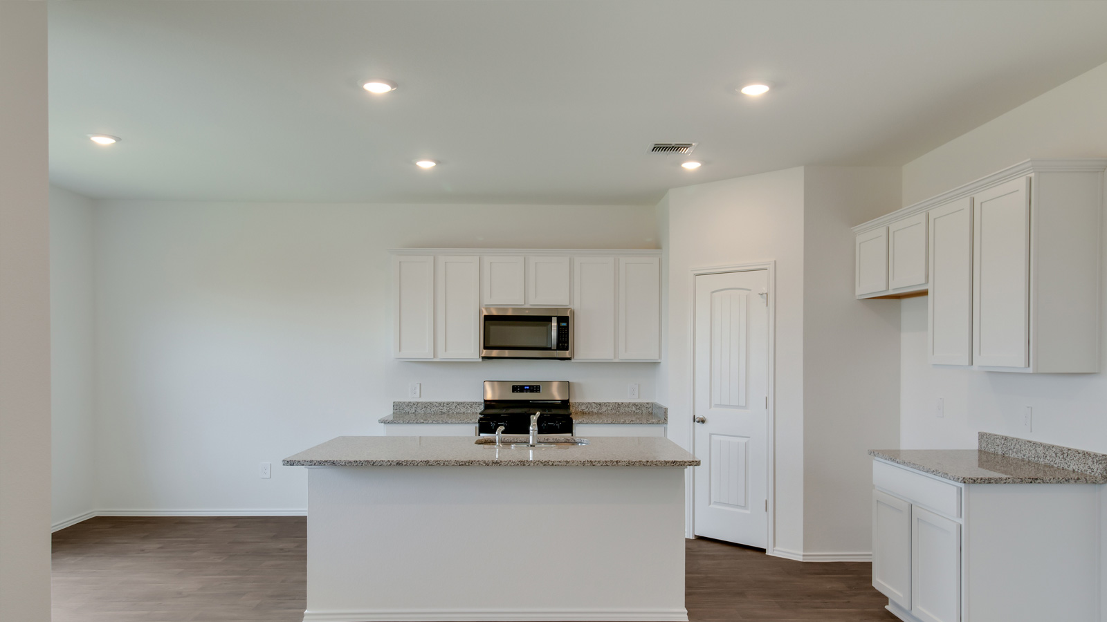 Modern kitchen with stainless steel appliances and granite countertops.