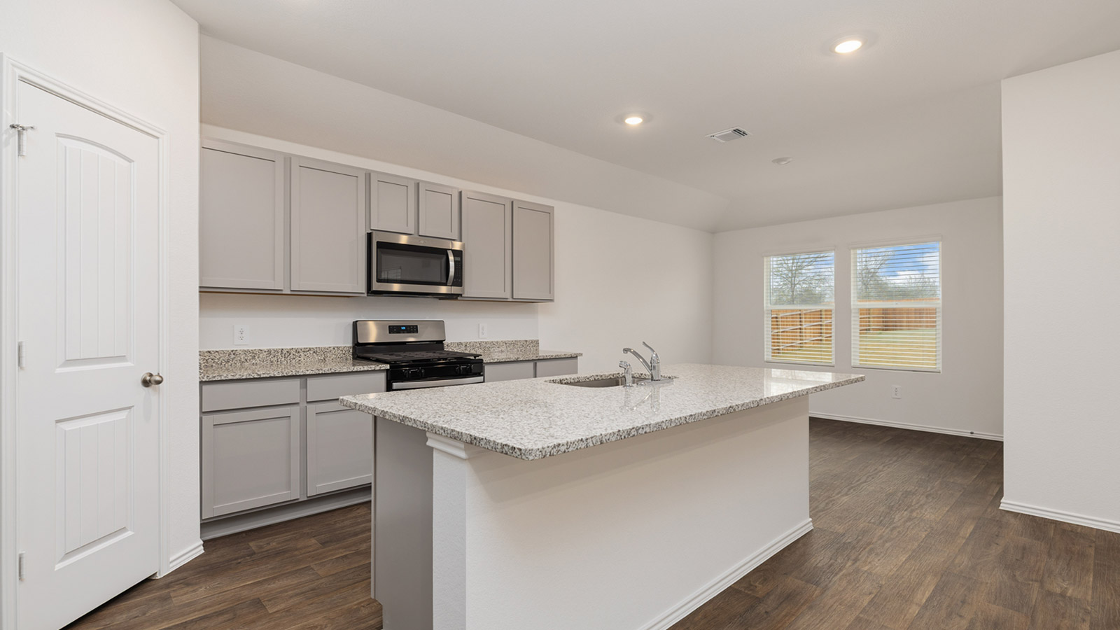 Kitchen with granite countertops and view of backyard.