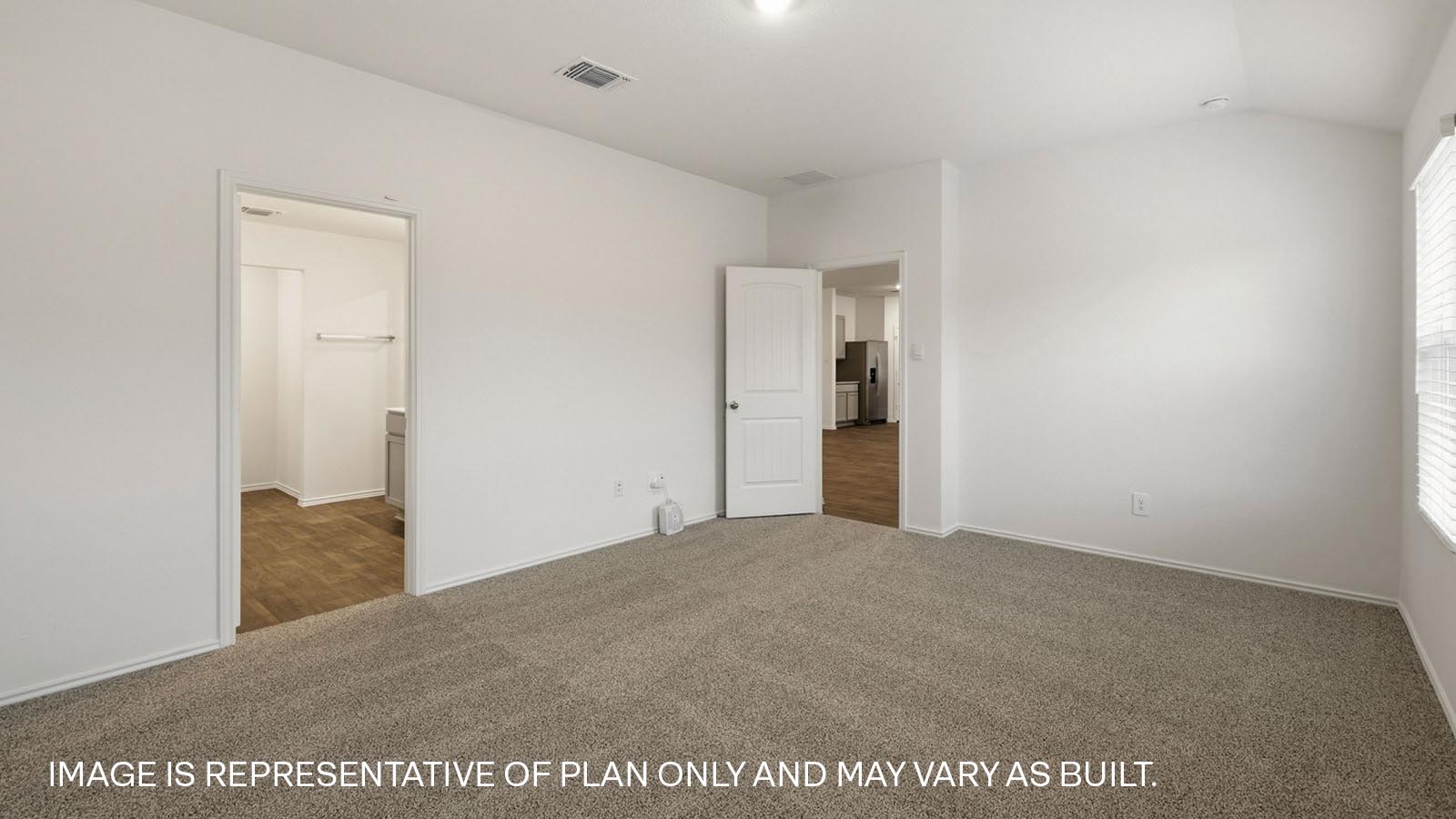 Primary bedroom with carpeted flooring and two windows.