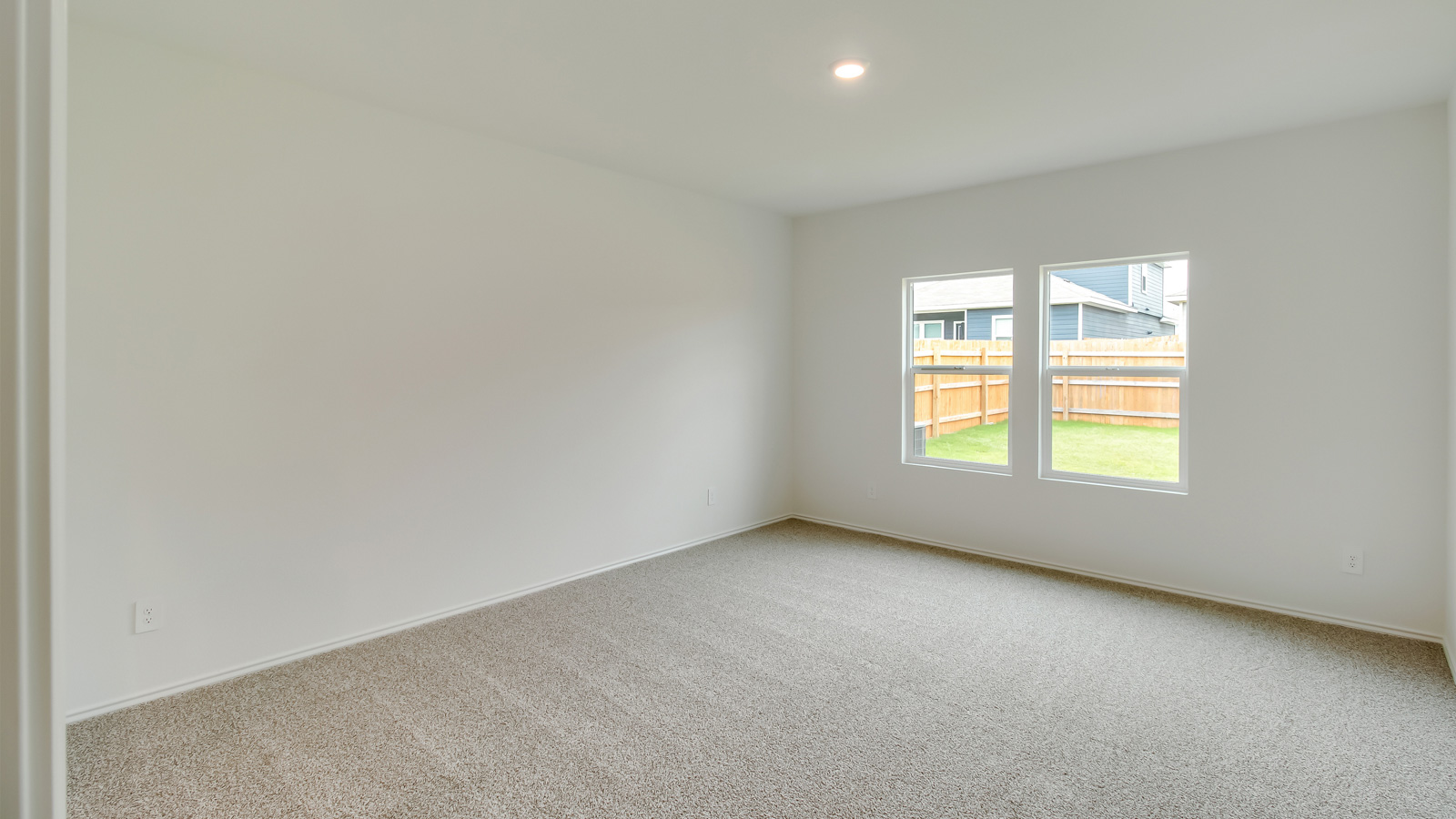 Carpeted floors and window in bedroom 1.