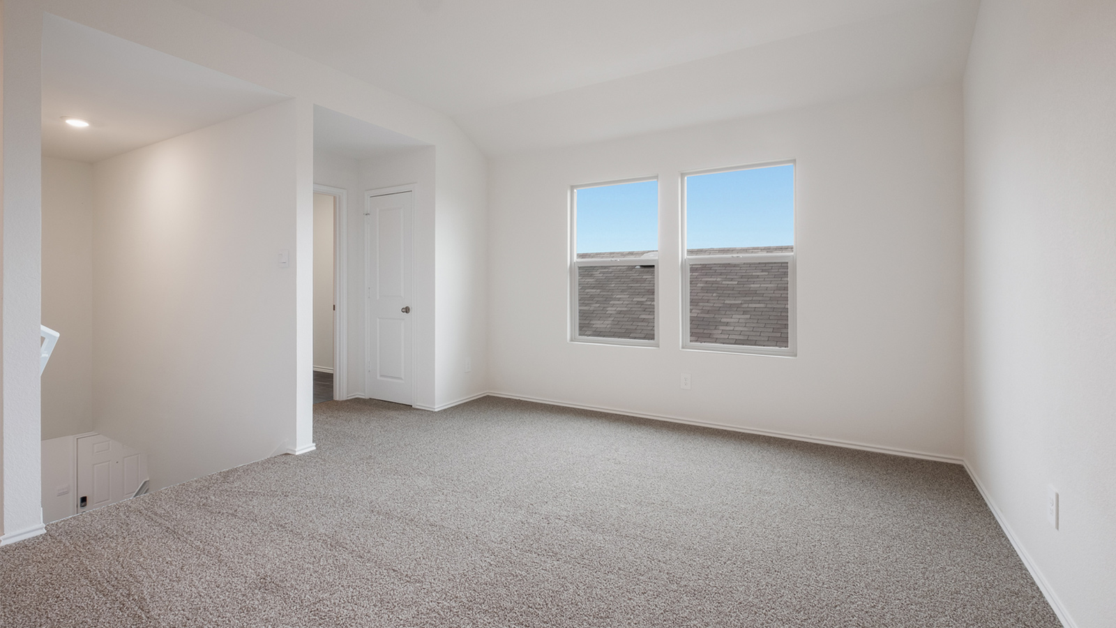 Upstairs gameroom with carpeted flooring.