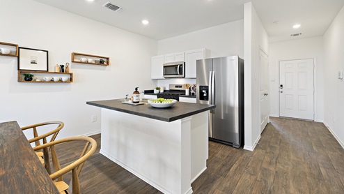 Beautiful modern kitchen with white cabinetry, stainless steel appliances and a large island