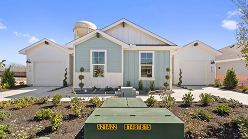Front exterior view of a 1 story blue and white siding modern farmhouse