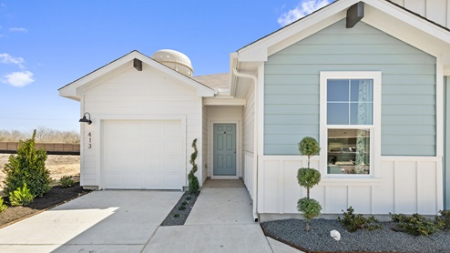 Front exterior view of a 1 story blue and white siding modern farmhouse