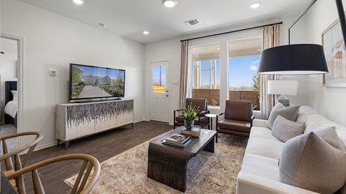 Interior view of the spacious living room decorated in greys, dark browns and white