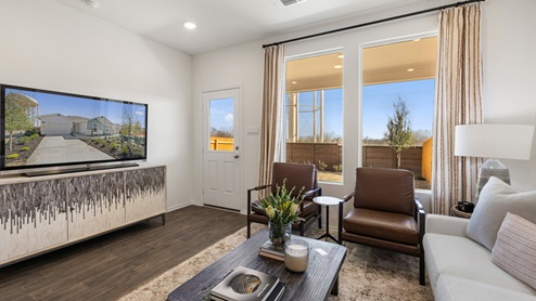 Interior view of the spacious living room decorated in greys, dark browns and white