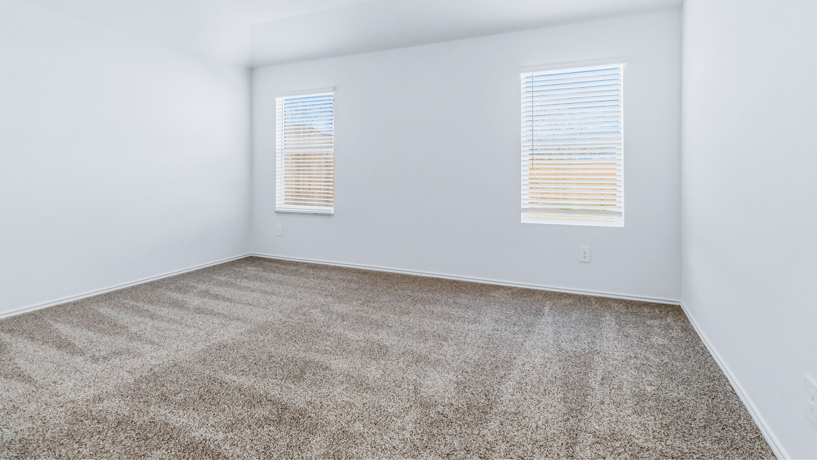 Primary bedroom features ample space, double windows, soft carpet, a stylish walk-in closet, and a private en suite bath