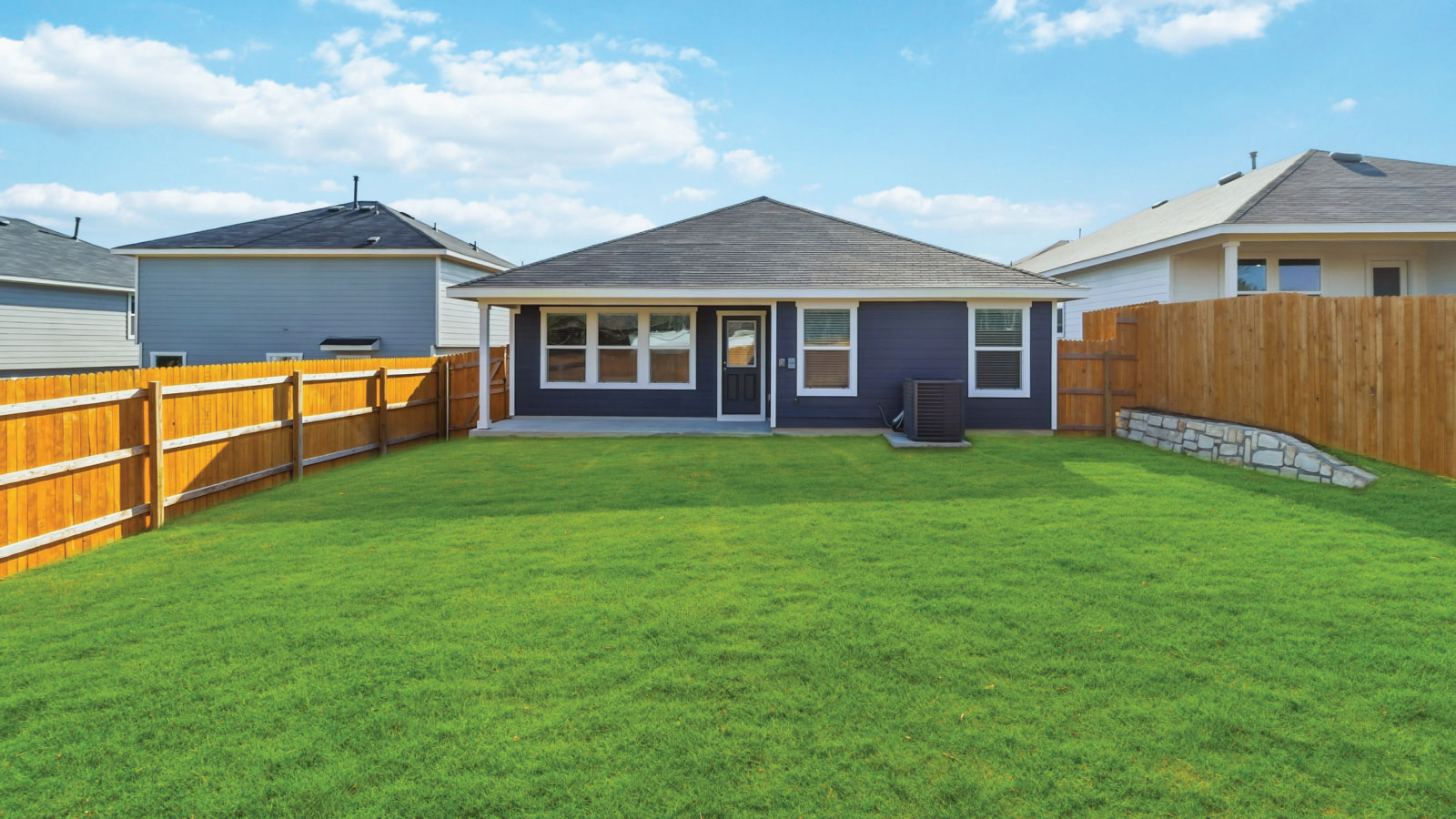 Backyard with concrete patio for seating, grill setup, and smooth indoor-outdoor transition Wayside