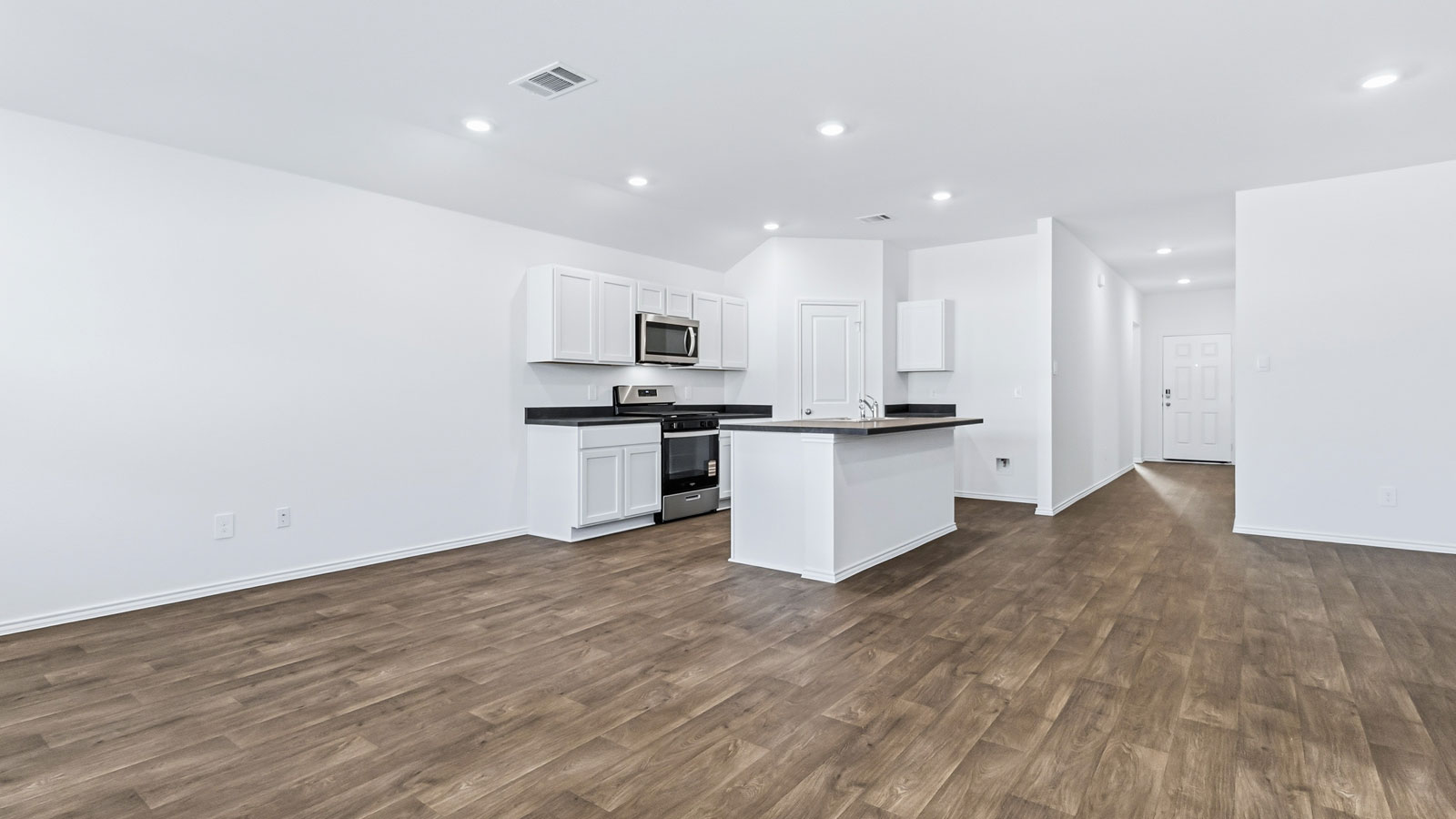 View from living room featuring natural light, fresh open concept design, kitchen and dining areas Wayside