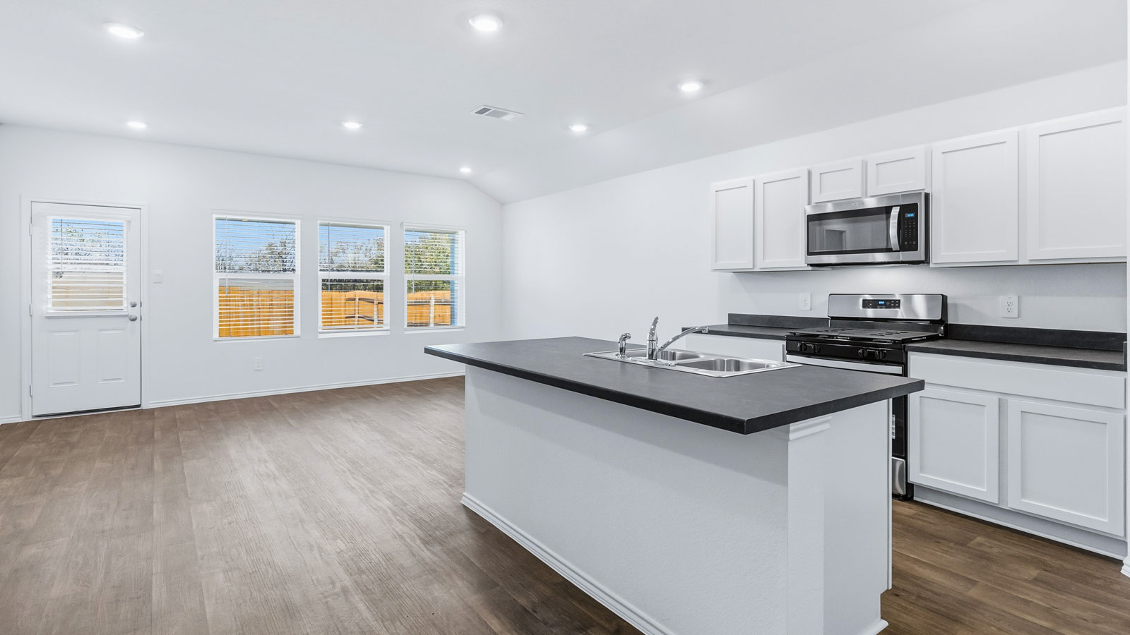 New appliance suite included, central kitchen island with sink, seating, next to dining, great room, and outdoor access