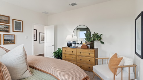 Wooden dresser in the primary bedroom across from the bed