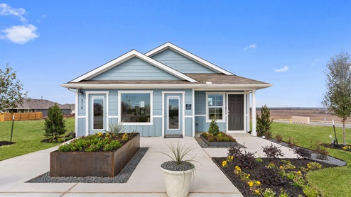 Front exterior of a 1 story model home with light blue siding and beautiful landscaping