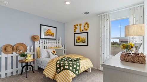 Bedroom with a sunflower decor theme. This bedroom features yellow, green and light blue decor and has a small window on the right wall