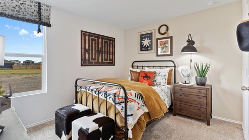Bedroom featuring cowboy decor with a western theme and a small window on the left wall