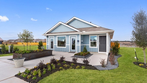 Front exterior of a 1 story model home with light blue siding and beautiful landscaping