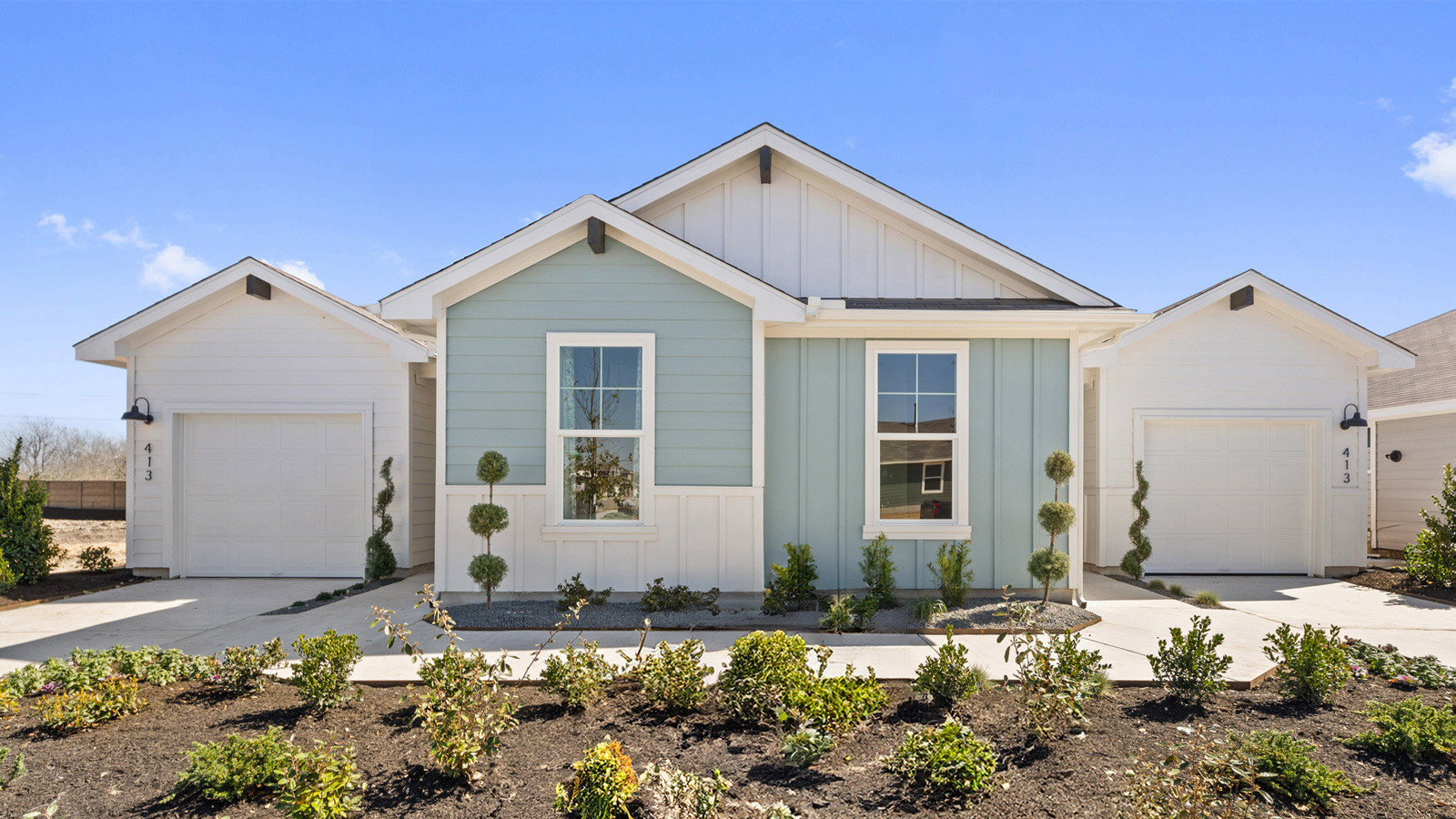 Front exterior view of a 1 story blue and white siding modern farmhouse
