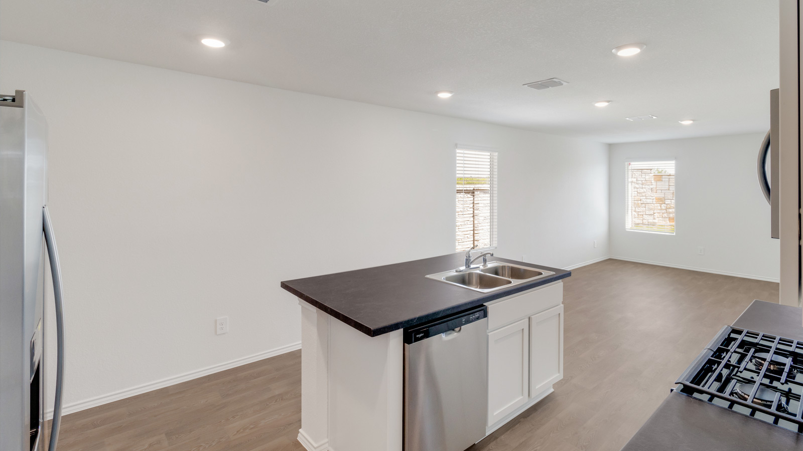 New Home kitchen island with bar seating, ample storage situated between the sink and new appliance cooking zone