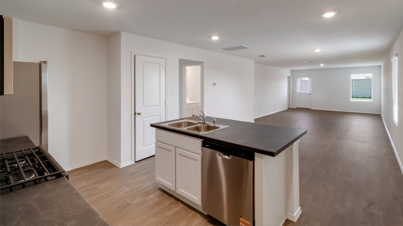 Kitchen island in D.R. Horton layout connects to dining and living areas with efficient flow and modern surface finishes