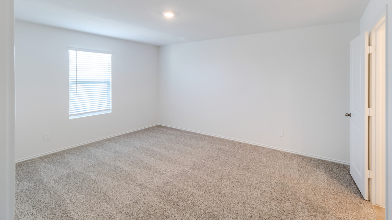 Primary suite at Wayside includes corner window views, walk-through access to an en suite bathroom, walk-in closet