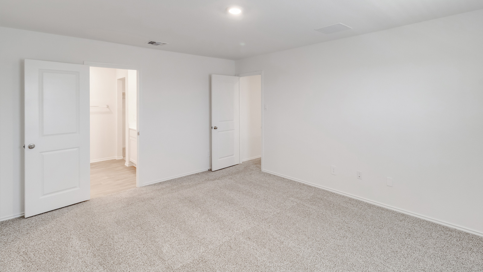 Primary bedroom designed for privacy and space with clean lines and a convenient flow into en-suite bathroom and walk-in closet