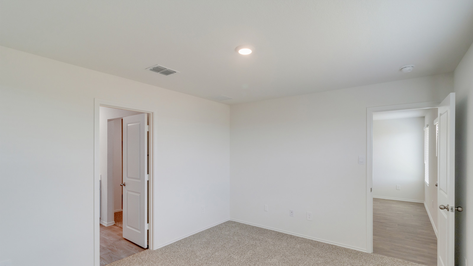 Main bedroom in this New Build Home in Wayside shows soft carpeting, en-suite bathroom and walk-in closet access