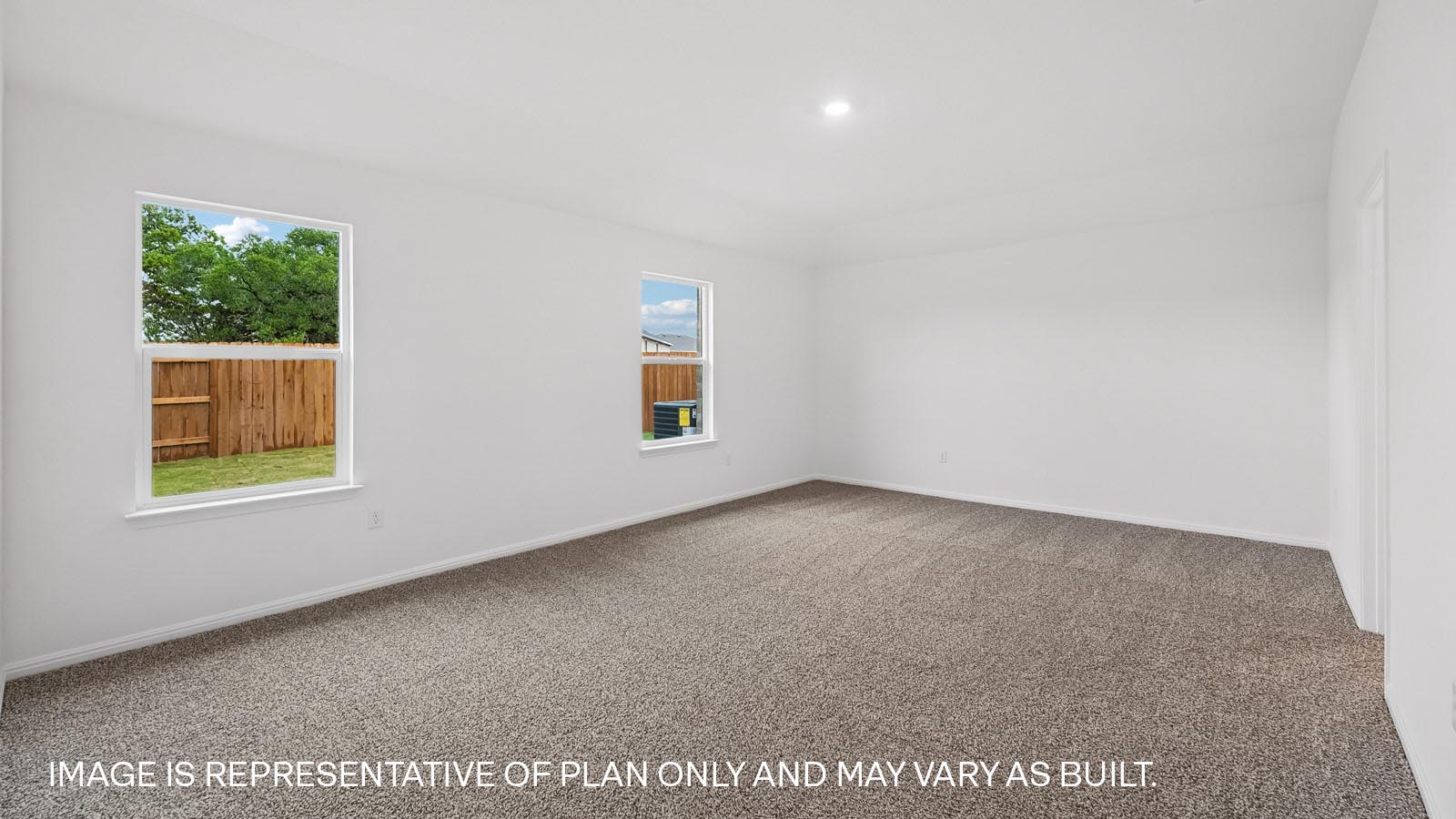 Primary bedroom with carpeted flooring and two windows.