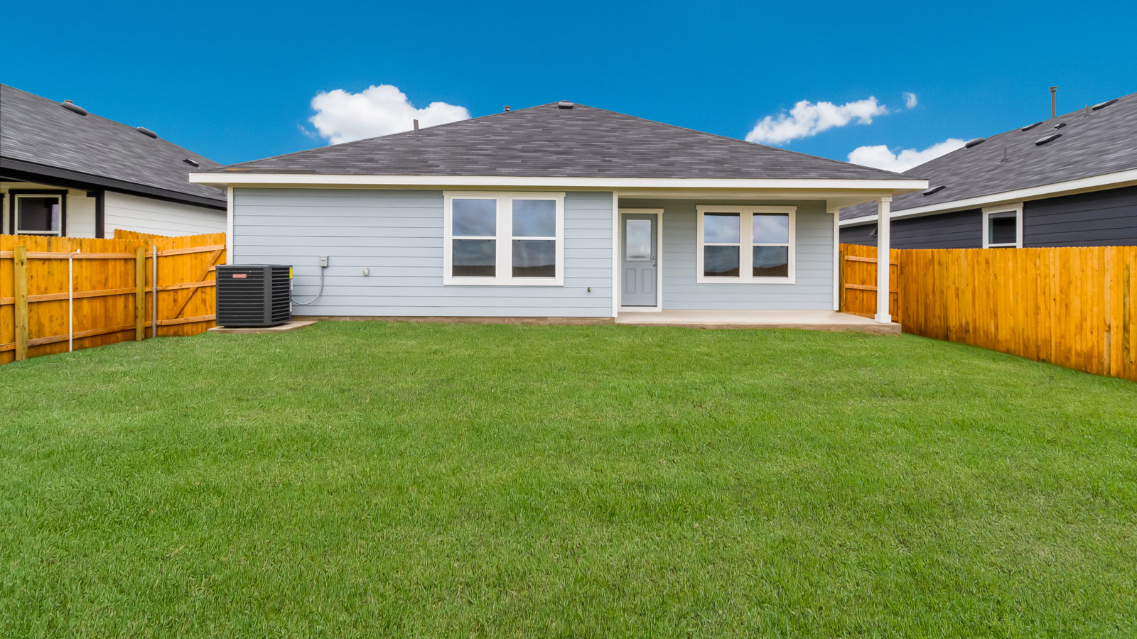 rear exterior of home featuring a spacious fenced in backyard