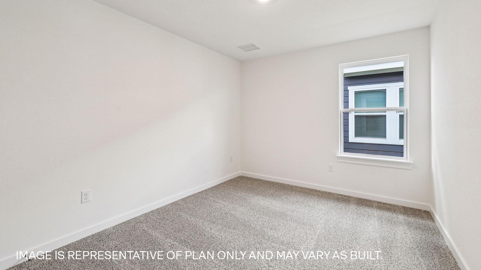 Secondary bedroom with carpeted flooring.