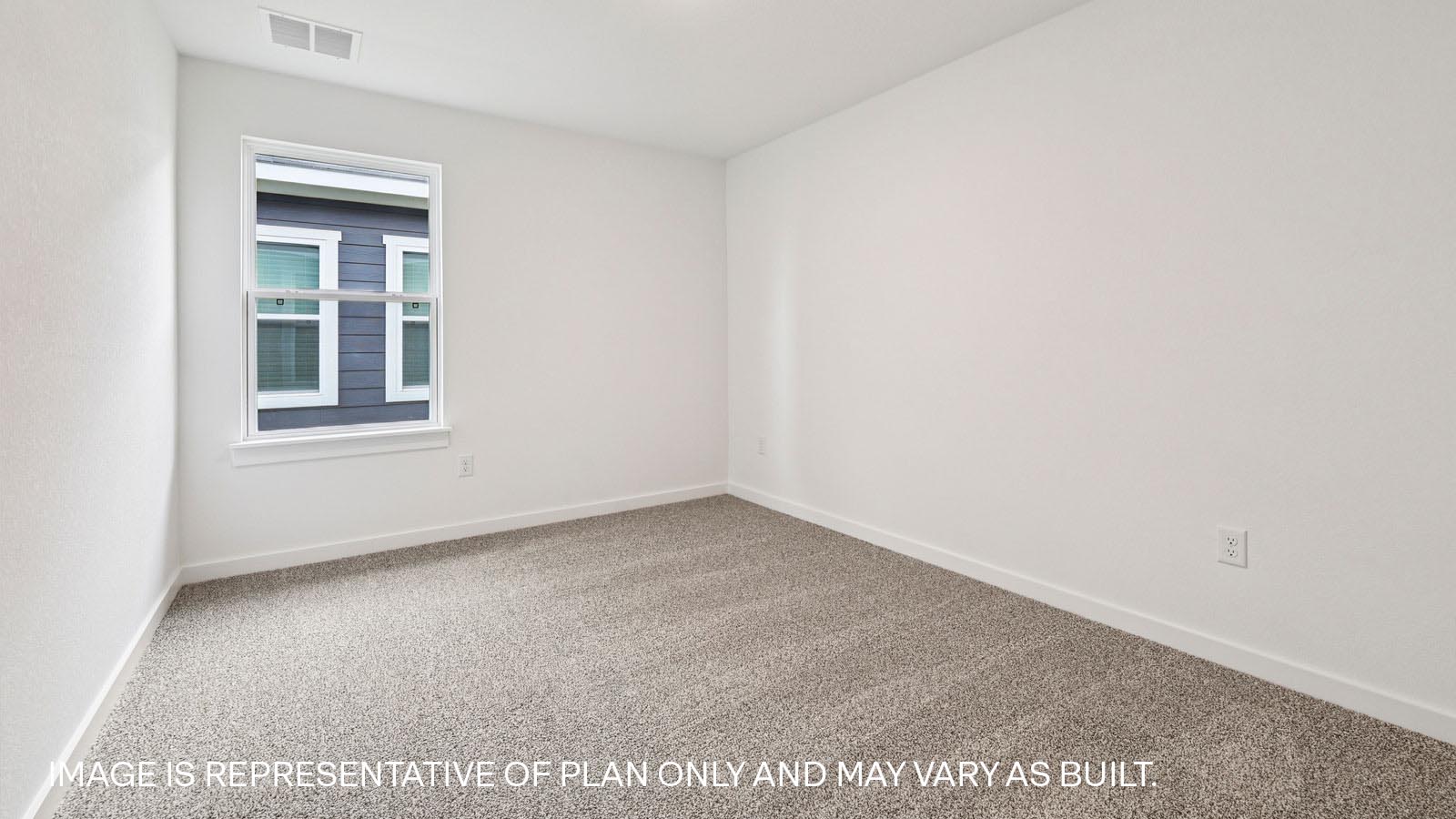 Secondary bedroom with carpeted flooring.