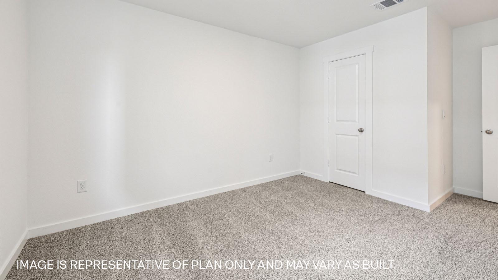 Secondary bedroom with carpeted flooring.