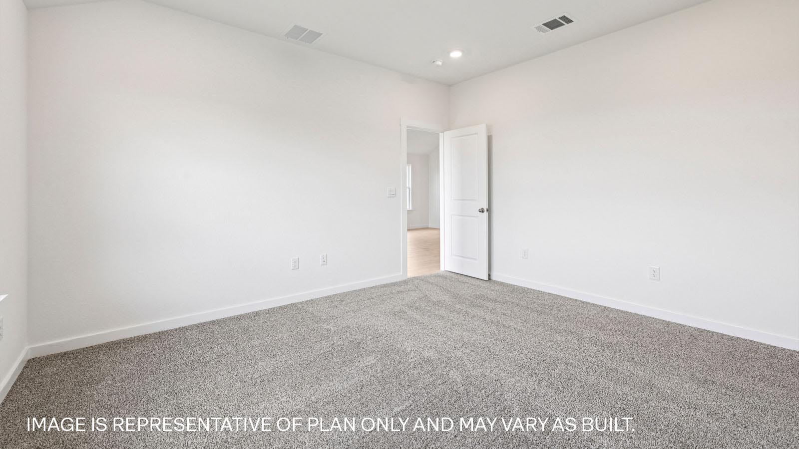 Primary bedroom with carpeted flooring and large window.