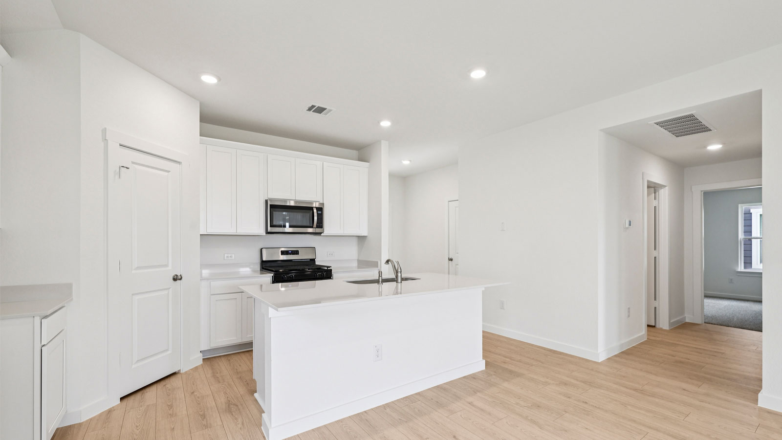 Modern kitchen and island with quartz countertops.