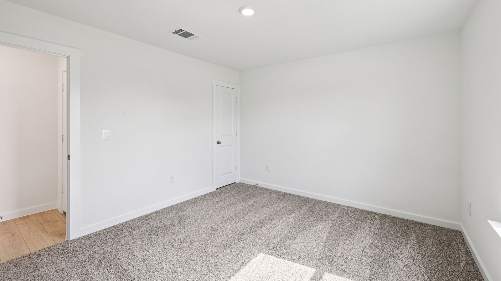 Secondary bedroom with carpeted flooring.