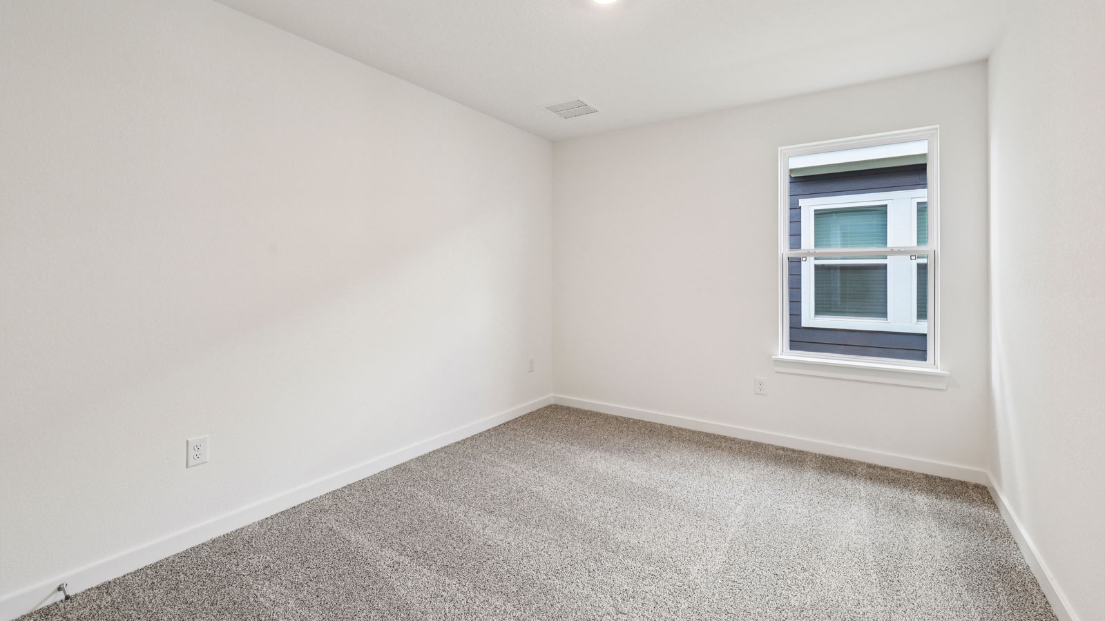 Secondary bedroom with carpeted flooring.