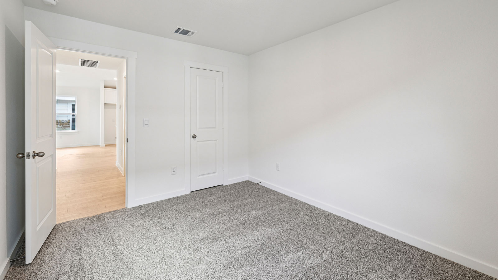 Secondary bedroom with carpeted flooring.