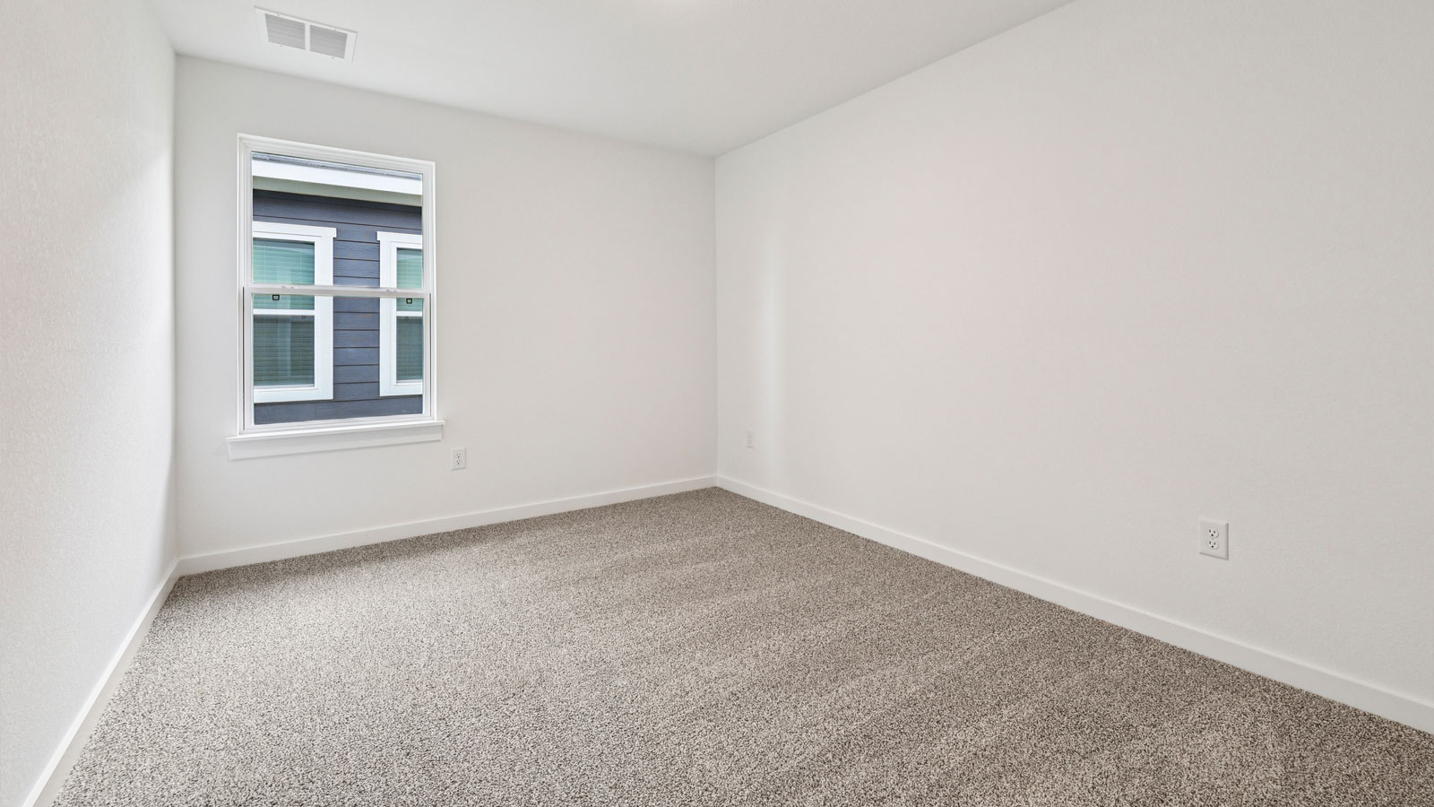 Secondary bedroom with carpeted flooring.