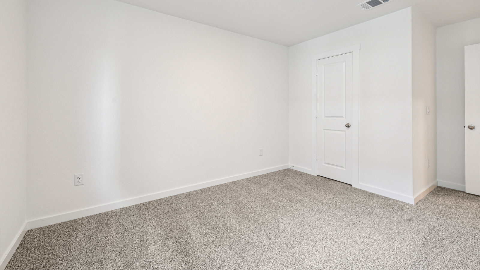 Secondary bedroom with carpeted flooring.