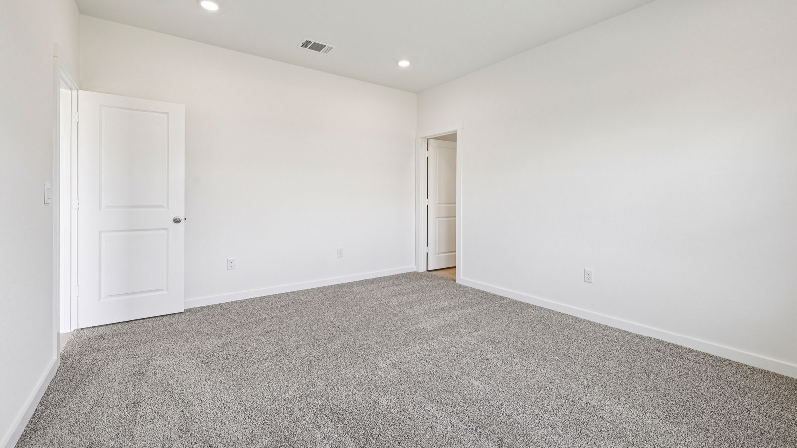 Primary bedroom with carpeted flooring and large window.