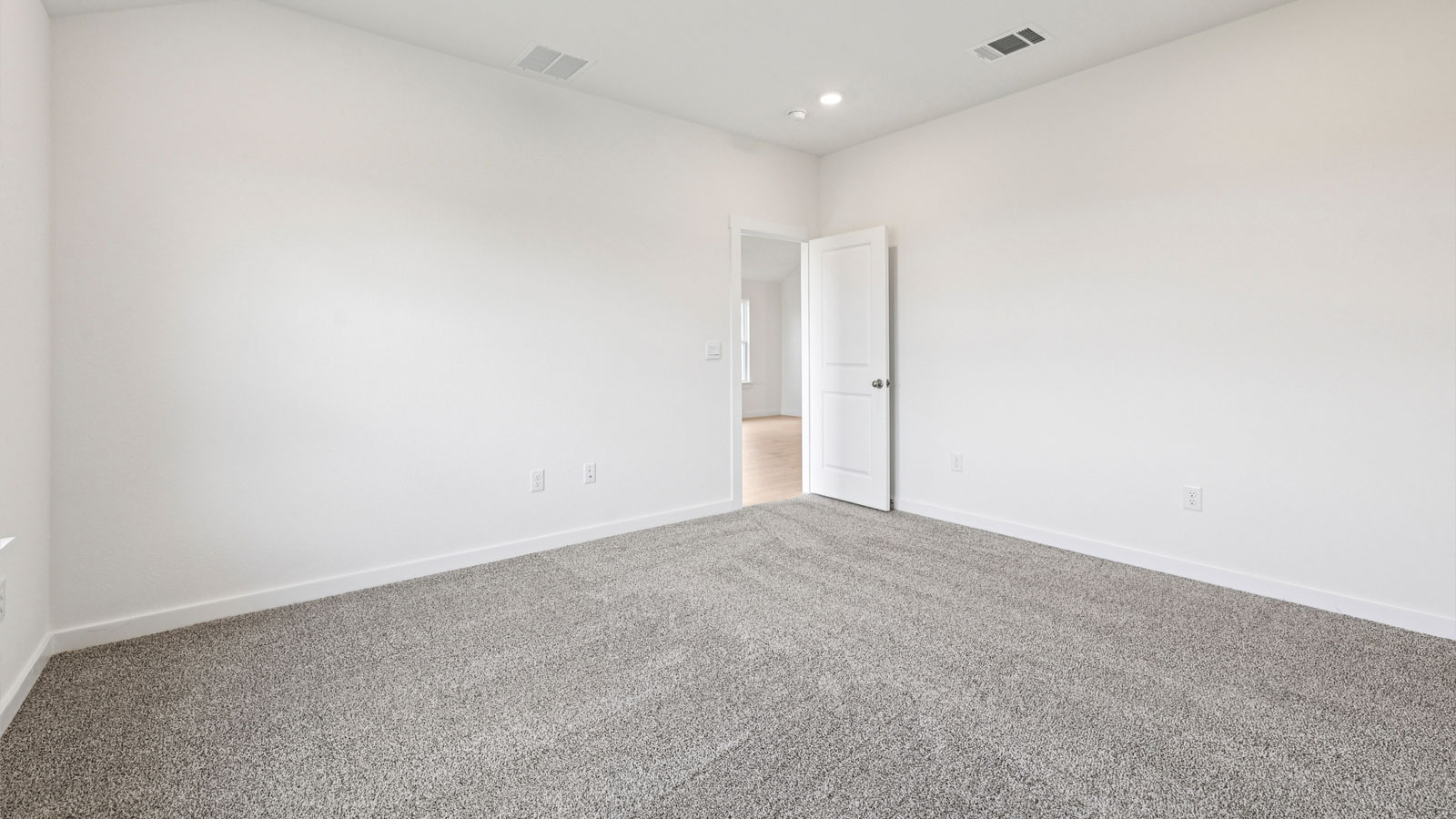 Primary bedroom with carpeted flooring and large window.