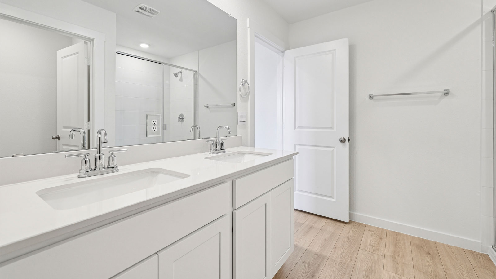 Luxurious primary bathroom with double vanity sink and walk-in shower.