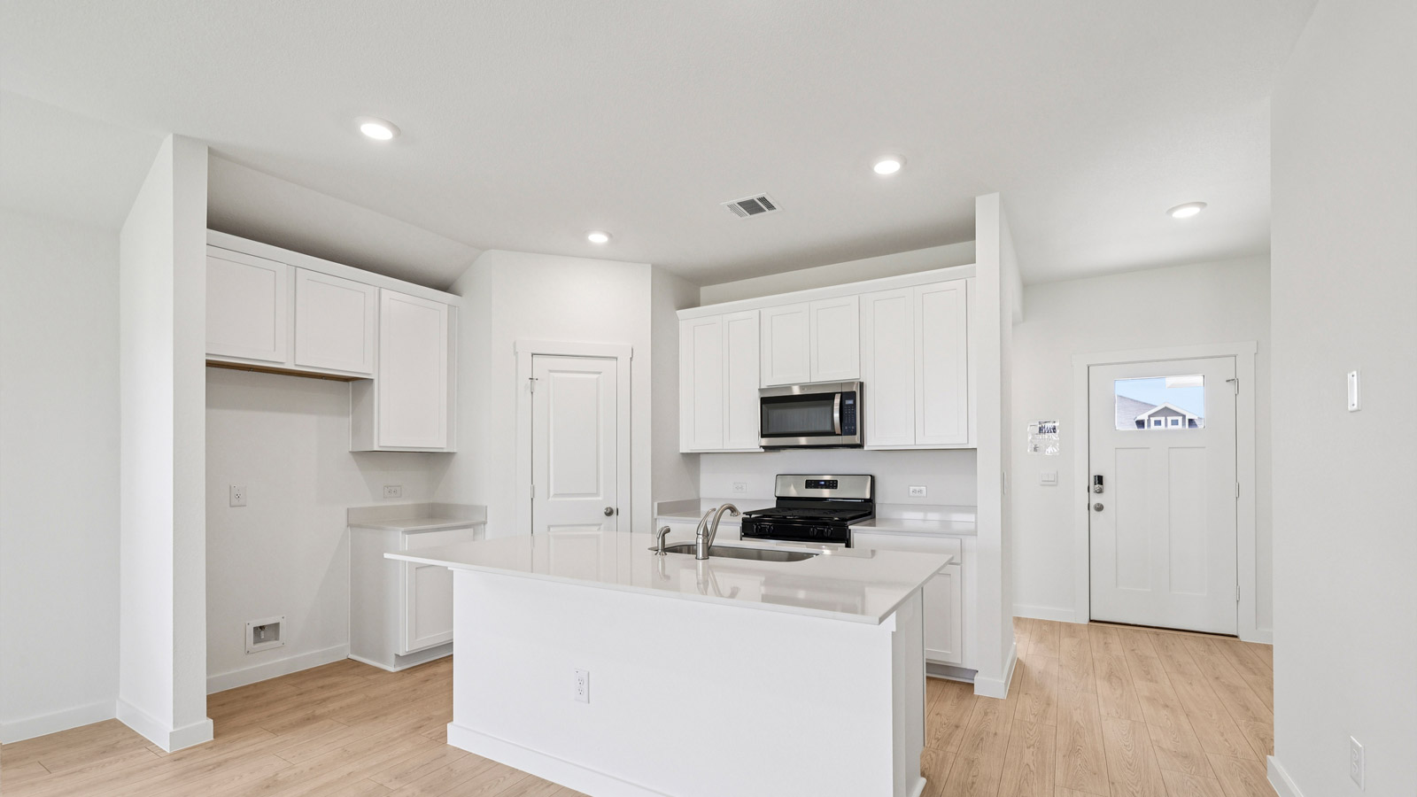 Kitchen with quartz countertops and white kitchen cabinets.