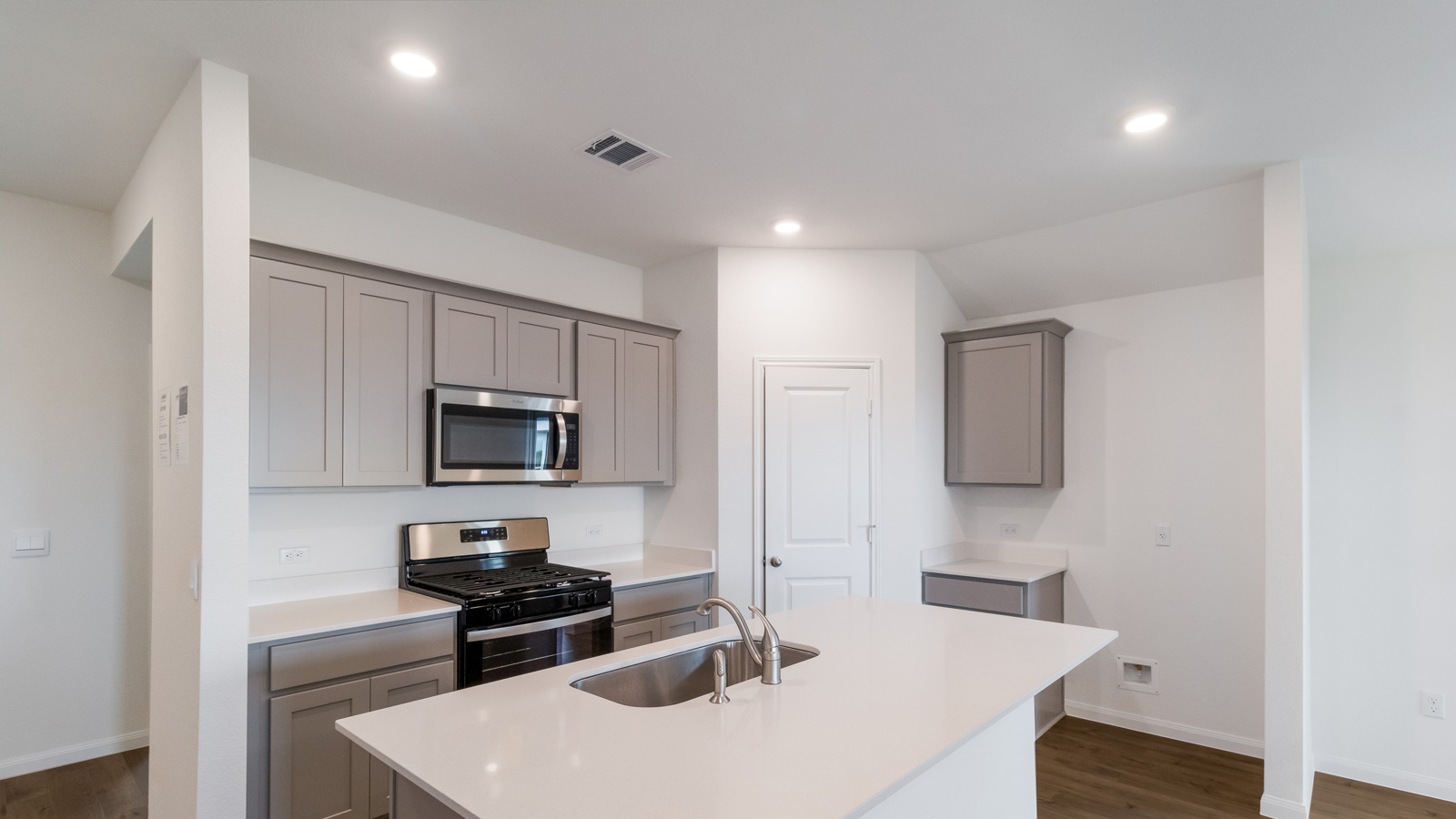 kitchen with light grey cabinetry, large island and stainless steel appliances