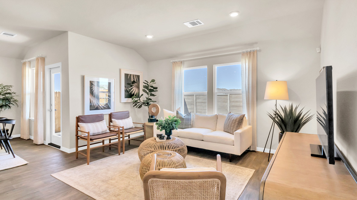 Open living with windows and laminated wood flooring.