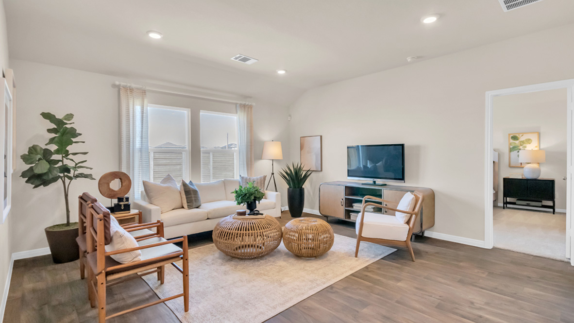 Open living with windows and laminated wood flooring.